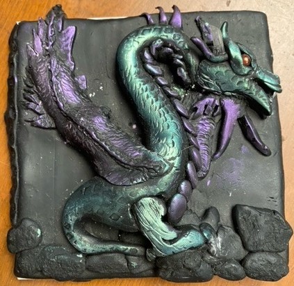 Image of a clay dragon sculpted on a tile
