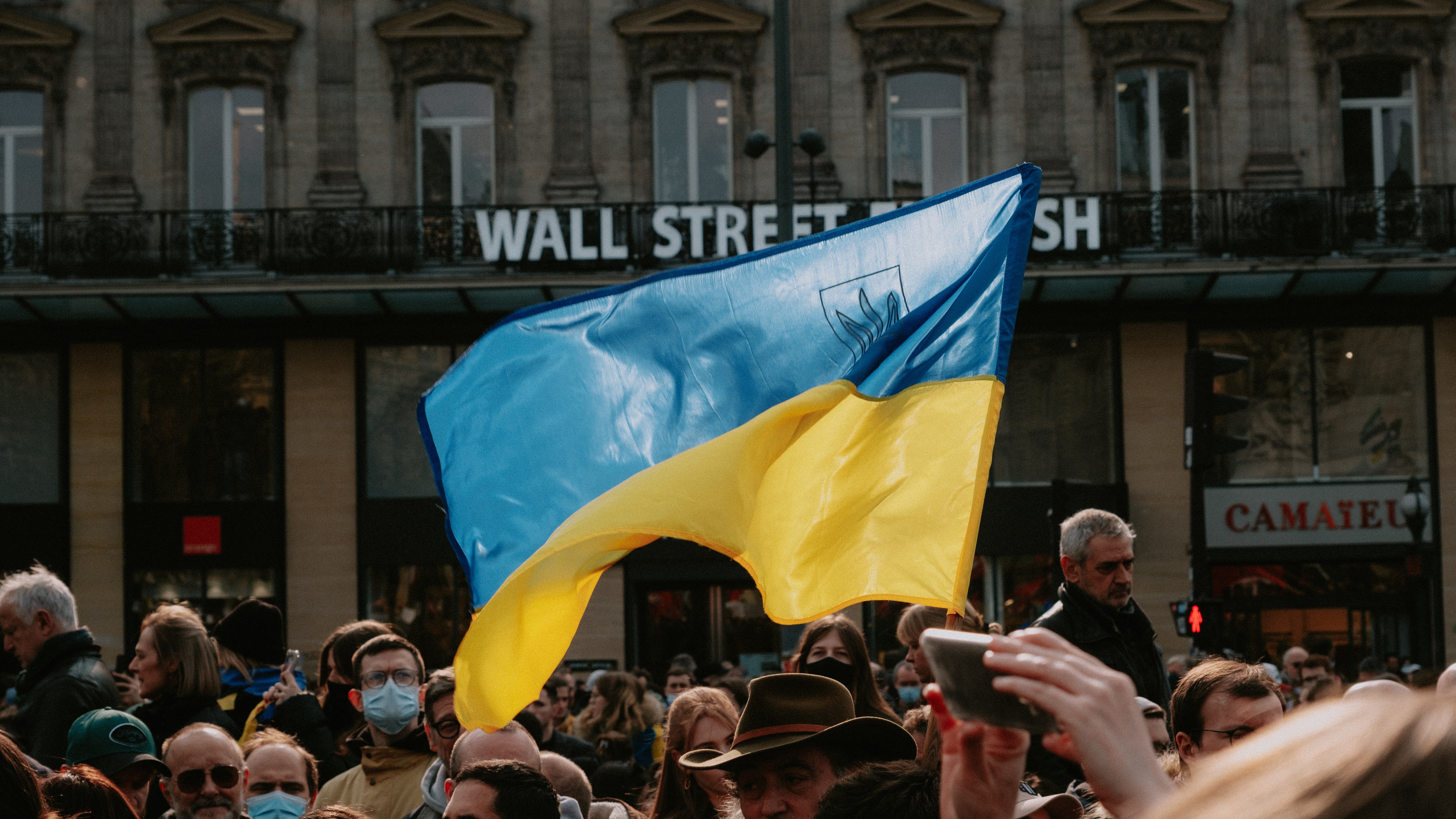 Ukrainian flag flying above a crowd