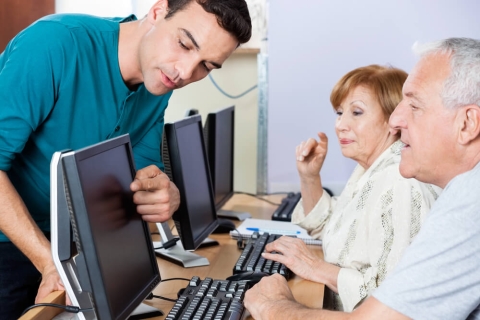 instructor showing senior citizens how to use a computer