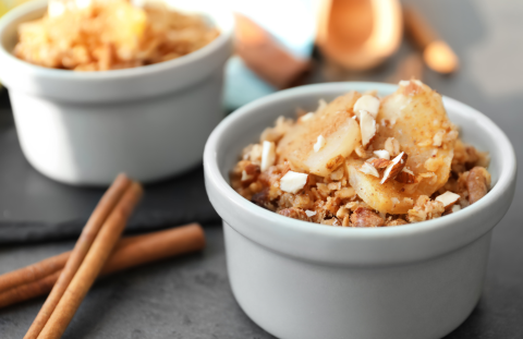 Photo of two mini apple cobblers in white dishes with cinnamon sticks