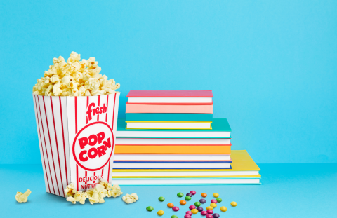 Books stacked with popcorn in the forefront
