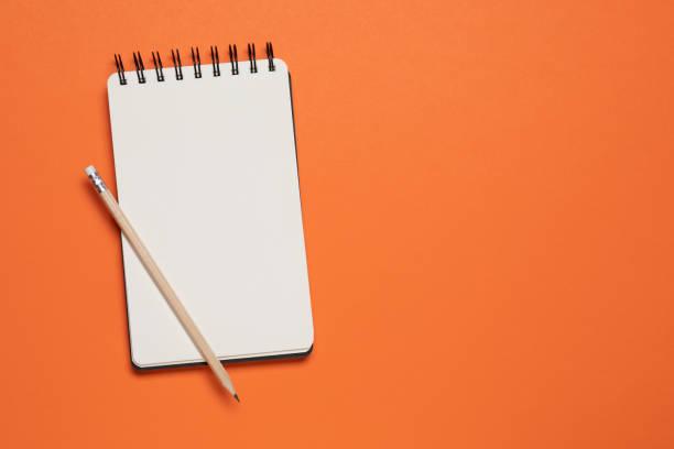 note pad on orange background