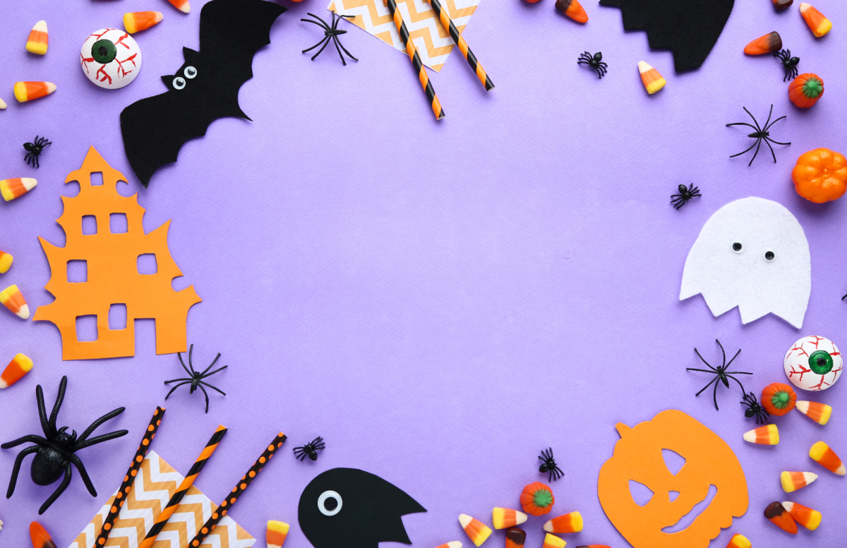 Purple background withe paper bats, ghosts, straws, candy and confetti surrounding the border